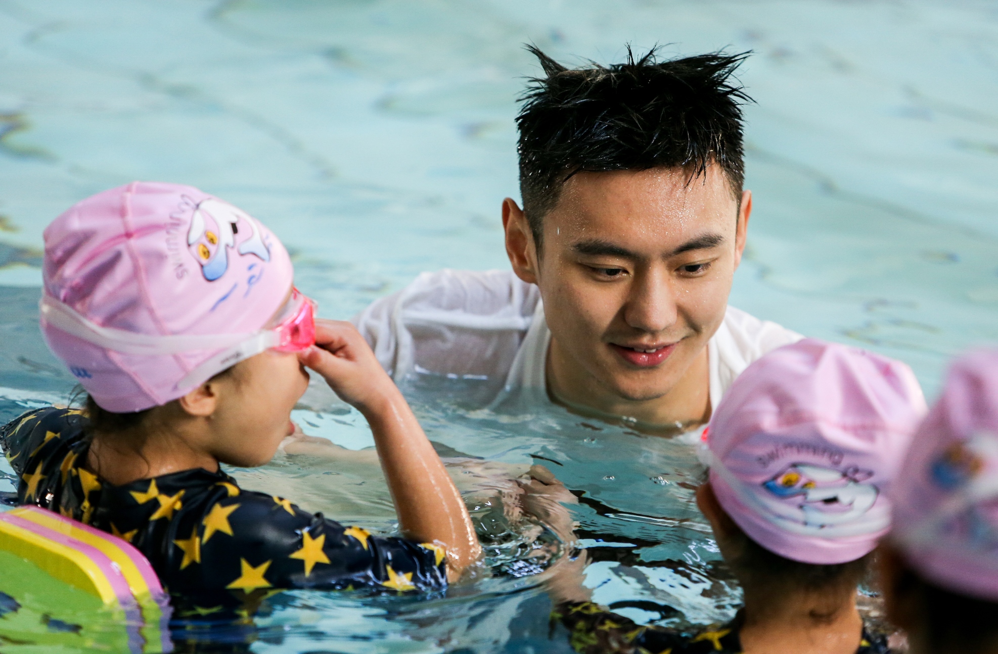 图注：经过项目救助后恢复健康的孩子们和宁泽涛一起学习游泳